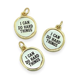 May include: Three gold-toned metal charms with a white background and black lettering. Each charm reads "I can do hard things".