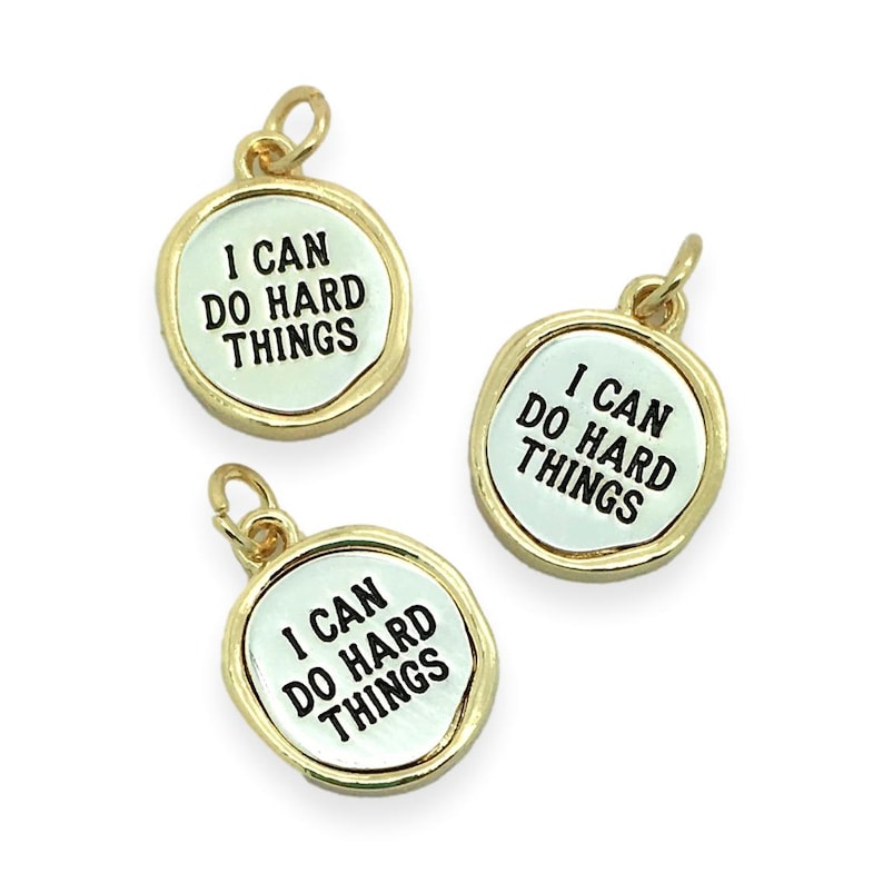 May include: Three gold-toned metal charms with a white background and black lettering. Each charm reads "I can do hard things".