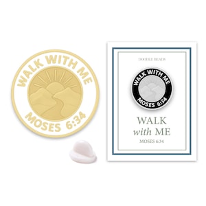 May include: Gold-colored pin with the text "WALK WITH ME MOSES 6:34" around a mountain and sun design. A white pin back is next to the pin. A card with the same pin design and text is also shown.