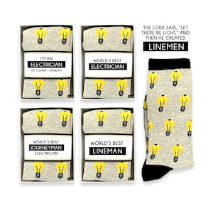Puede incluir: Cuatro cajas de regalo con diseños de bombillas y el texto "World's Best Electrician", "World's Best Journeyman Electrician", "World's Best Lineman" y "I'm an Electrician, of course I conduiti". Un par de calcetines grises con ribetes negros y un patrón de bombillas. El texto "The Lord said, "Let there be light," and then he created Linemen" está por encima de los calcetines.