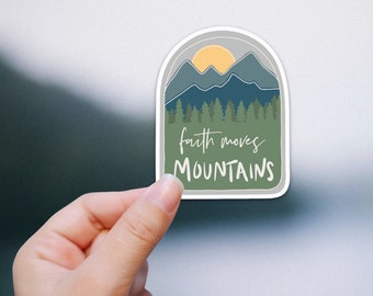 May include: A sticker with a green, blue, and yellow mountain scene with a sun and the text "faith moves mountains".