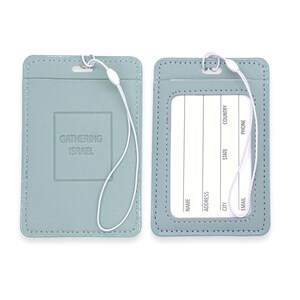 May include: Two light blue leather luggage tags with a white string attached. The tag on the left has the text "Gathering Israel" embossed on it. The tag on the right has a clear plastic window for inserting a name card and spaces for writing contact information.