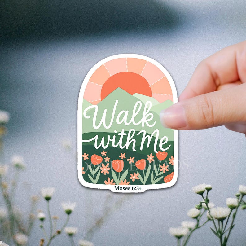 May include: A sticker with a nature-themed design. The sticker features the text "Walk with Me" in white script, with a backdrop of a sunset, mountains, and flowers. The text "Moses 6:34" is at the bottom.