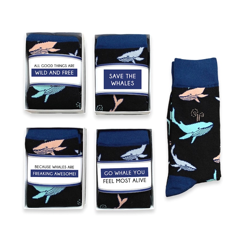 May include: Black socks with a blue cuff and whale pattern, packaged in boxes. The socks feature whales in teal and pink, with text labels saying "ALL GOOD THINGS ARE WILD AND FREE", "SAVE THE WHALES", "BECAUSE WHALES ARE FREAKING AWESOME!", and "GO WHALE YOU FEEL MOST ALIVE".