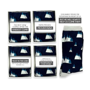 May include: Four pairs of socks with a mountain pattern and inspirational quotes. The quotes are: "The best view comes after the hardest climb", "Faith moves mountains", "Trust in the Lord and he shall direct thy paths, Proverbs 3:5-6", and "Limitless is your potential, magnificent is your future".