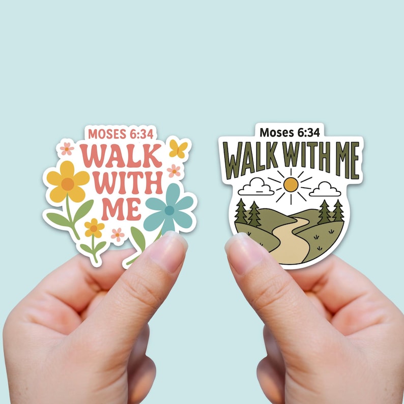 May include: Two stickers with the text "Walk With Me" from Moses 6:34. One sticker features flowers in yellow, orange, and blue. The other sticker shows a path, trees, and a sun. Both stickers are held up by a person.