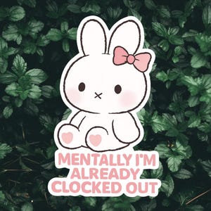 May include: A white bunny sticker with a pink bow, blush, and heart-shaped feet. The sticker has the text "MENTALLY I'M ALREADY CLOCKED OUT" in pink. The background is a lush green foliage.