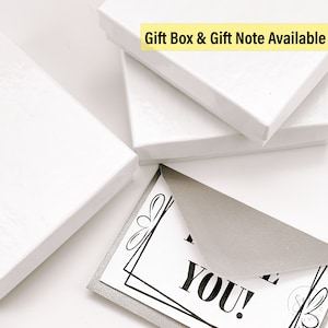 May include: A white gift box with a silver glitter card that says "Thank You!" inside. The text "Gift Box & Gift Note Available" is written in yellow on the top of the box.
