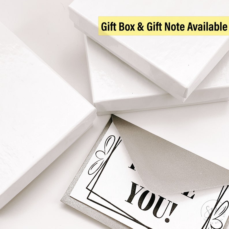 May include: A white gift box with a silver glitter card that says "Thank You!" inside. The text "Gift Box & Gift Note Available" is written in yellow on the top of the box.