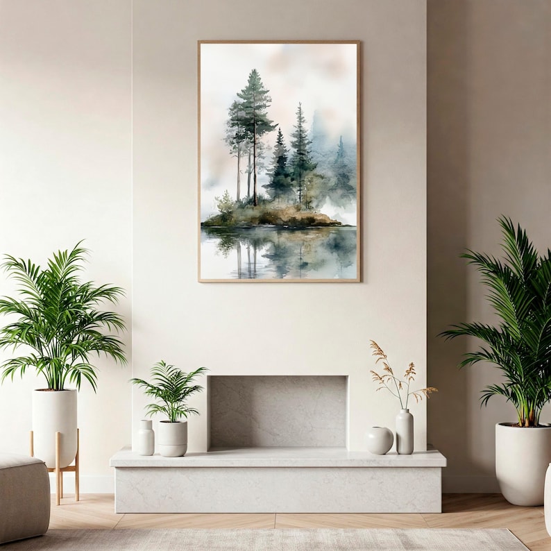 May include: A watercolour painting of a misty forest scene with tall trees reflected in a still body of water. The painting is framed in a light wood frame and hangs on a white wall.
