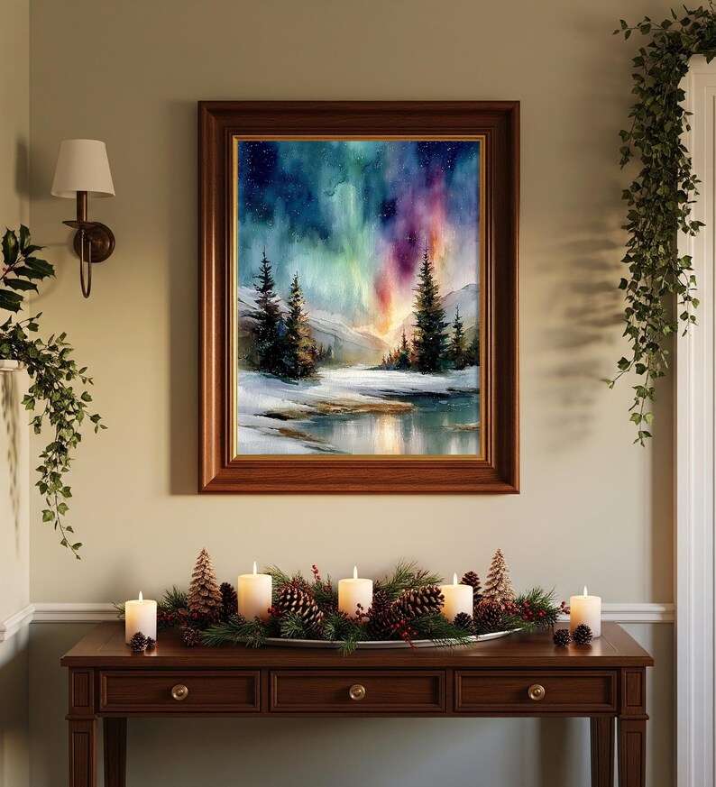 Puede incluir: Una pintura de paisaje enmarcada representa una escena invernal con una colorida aurora boreal. La obra de arte est&aacute; en un marco de madera oscura y cuelga sobre una consola de madera. La mesa est&aacute; decorada con velas, pi&ntilde;as y vegetaci&oacute;n.