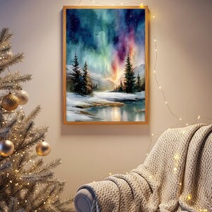 Puede incluir: Una pintura de acuarela enmarcada representa un paisaje invernal con una aurora boreal. La obra de arte presenta una vibrante exhibici&oacute;n de luces verdes, moradas y azules sobre una escena nevada con &aacute;rboles de hoja perenne y una masa de agua reflectante. El marco es de madera marr&oacute;n claro.