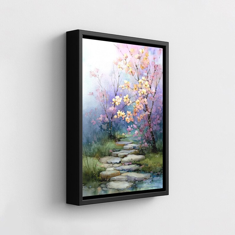 May include: A framed watercolor painting depicts a serene garden scene. A stone path winds through lush greenery and under flowering trees with pink and yellow blossoms. The artwork is framed in a black rectangular frame.