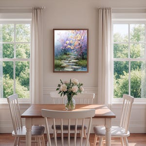 May include: A framed watercolor painting depicts a serene pathway through a lush garden. The artwork features a stone path leading to a pond, with trees in bloom. The color palette includes soft blues, greens, and pinks, creating a tranquil scene.
