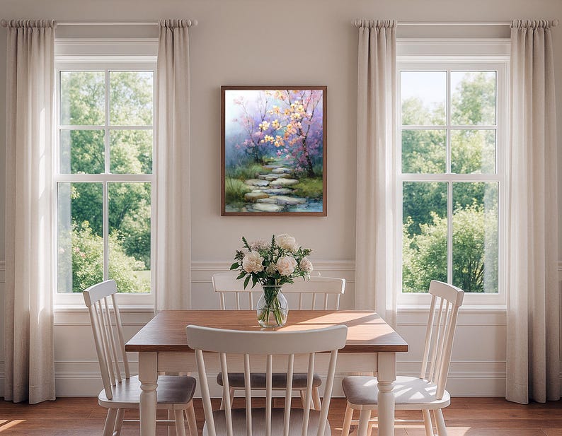May include: A framed watercolor painting depicts a serene pathway through a lush garden. The artwork features a stone path leading to a pond, with trees in bloom. The color palette includes soft blues, greens, and pinks, creating a tranquil scene.