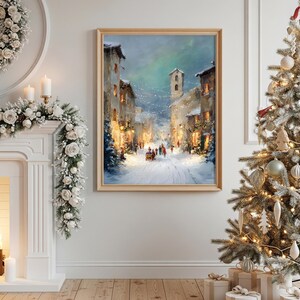 Puede incluir: Pintura enmarcada de una escena de calle invernal. La obra representa una carretera nevada bordeada de edificios iluminados por luces c&aacute;lidas. La gente camina por la calle. La pintura est&aacute; en un marco de madera clara.