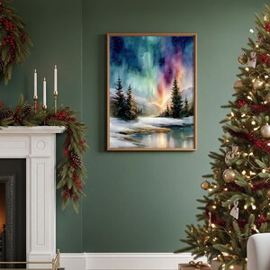 Puede incluir: Una pintura de acuarela enmarcada representa un paisaje invernal con una vibrante aurora boreal. La obra presenta una escena nevada con &aacute;rboles de hoja perenne, una masa de agua reflectante y un cielo colorido en tonos azules, verdes y morados. El marco es de color marr&oacute;n claro.