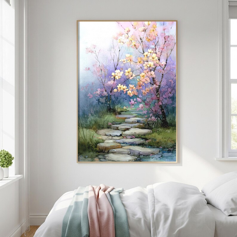 May include: Watercolor painting of a serene garden path. The artwork features a stone pathway leading through a lush landscape with blooming trees in shades of pink and yellow. The painting is framed in a light wood.