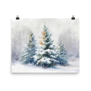 May include: Watercolor print of a winter scene featuring snow-covered evergreen trees. The artwork depicts a snowy landscape with falling snowflakes and a soft, muted color palette of blues, greens, and whites. The print is attached to a white background with a black clip.