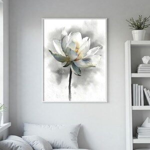 May include: Watercolor painting of a white lotus flower with a yellow center and green-tinged petals. The flower is set against a soft, gray and white background, framed in a white border. The artwork is a botanical theme.