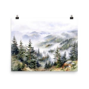 May include: Watercolor painting of a misty mountain landscape. The artwork features evergreen trees in the foreground, with layers of hills and mountains fading into the distance. The color palette includes greens, blues, and whites.