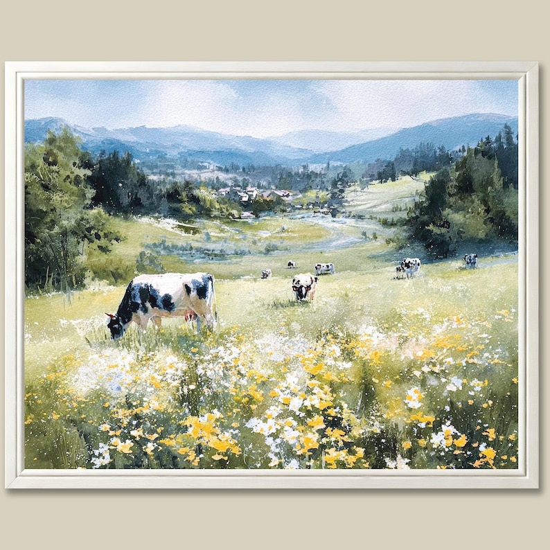 May include: A framed watercolor painting of a pastoral scene. Cows graze in a field of wildflowers, with a backdrop of rolling hills and a distant village. The artwork features a palette of greens, blues, and yellows.