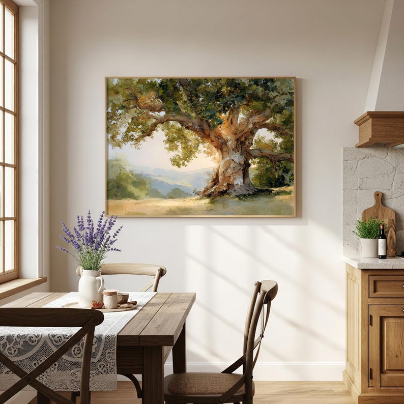 May include: A framed landscape painting of a large oak tree with lush green foliage and a thick, textured trunk. The artwork features a warm color palette with golden sunlight filtering through the branches. The painting is displayed above a wooden dining table.
