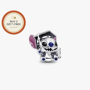 May include: A silver charm featuring a cartoon character wearing a graduation cap and holding a diploma. The character has large black eyes, blue accents, and pink ears. The charm is detailed and sits on a white background.