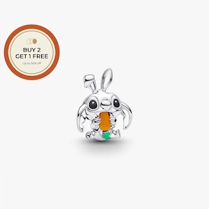 May include: A silver-colored charm in the shape of a cartoon character with large eyes and rabbit-like ears, holding an orange carrot. The charm has a green accent and is set against a white background. The image also includes a circular graphic with text that reads "BUY 2 GET 1 FREE Up to 50% off."