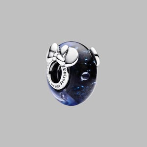 Pode incluir: Um berloque de prata com um n&uacute;cleo azul escuro e preto, com um la&ccedil;o e dois detalhes circulares. O berloque tem as palavras "Disney" e "S925 ALE" gravadas.
