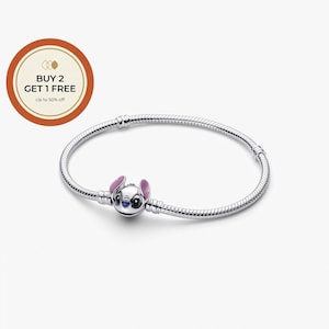 Puede incluir: Una pulsera de plata con un charm de Stitch. El charm representa al personaje de Disney con cara blanca, ojos azules y orejas rosas. La pulsera tiene un dise&ntilde;o de cadena de serpiente. La imagen tambi&eacute;n incluye una oferta promocional.