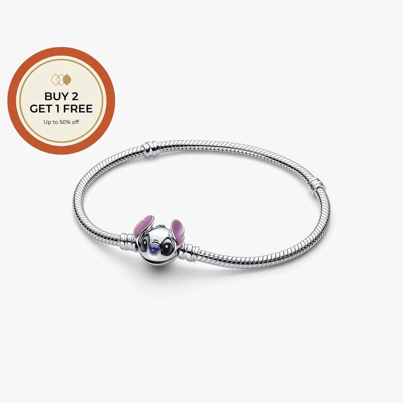 Puede incluir: Una pulsera de plata con un charm de Stitch. El charm representa al personaje de Disney con cara blanca, ojos azules y orejas rosas. La pulsera tiene un dise&ntilde;o de cadena de serpiente. La imagen tambi&eacute;n incluye una oferta promocional.