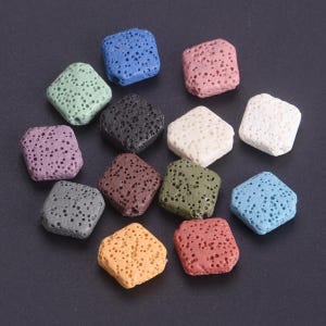 May include: A collection of square-shaped beads with a porous, textured surface. The beads are available in a variety of colors including blue, pink, white, black, green, purple, brown, gray, yellow, and red, each featuring a distinct pitted finish.