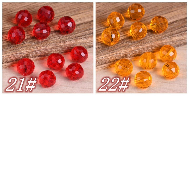 May include: Two sets of faceted glass beads, one set is red and the other is orange. The beads are arranged in a semi-circle on a wooden surface. The text "21#" and "22#" are printed below each set of beads.