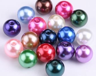 May include: Assortment of round, pearl-like beads in various colors, including pink, blue, green, purple, and brown. The beads are smooth and shiny, with a slight iridescent sheen.