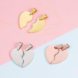 May include: Three sets of heart-shaped pendant necklaces in gold, silver, and rose gold. Each pendant is split in two, designed to be worn by two people. The pendants are displayed on a pink and blue background.