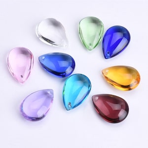 Puede incluir: Surtido de prismas de cristal en forma de lágrima en varios colores, incluyendo transparente, rosa, azul claro, azul oscuro, verde, morado, amarillo y rojo. Los prismas tienen un agujero en la parte superior para colgar.