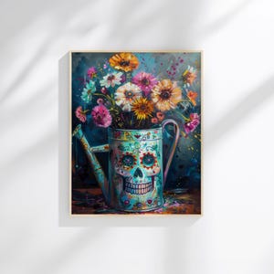 May include: A framed painting of a watering can decorated with a sugar skull design, filled with colorful flowers. The flowers include orange, pink, and white blooms. The background is a dark blue with paint splatters.