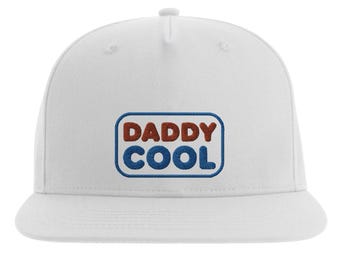 May include: White flat-peak cap featuring the embroidered words "DADDY COOL" in red and blue. The cap has a structured front and a flat peak, suitable for casual wear.