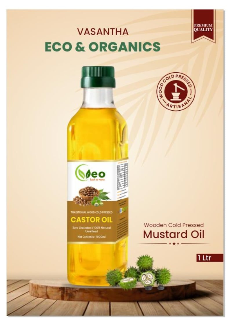 Puede incluir: Una botella de vidrio transparente de 1000 ml de aceite de ricino prensado en fr&iacute;o de madera con una etiqueta verde que dice "Vasantha Eco & Organics" y "Traditional Wood Cold Pressed Castor Oil". La botella est&aacute; sobre una superficie de madera con una planta verde en el fondo.