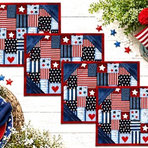 May include: Four patriotic placemats with a patchwork design featuring red, white, and blue fabrics. Each placemat has a red border, a blue corner, and includes stars, stripes, and hearts. The placemats are arranged on a white wooden surface.