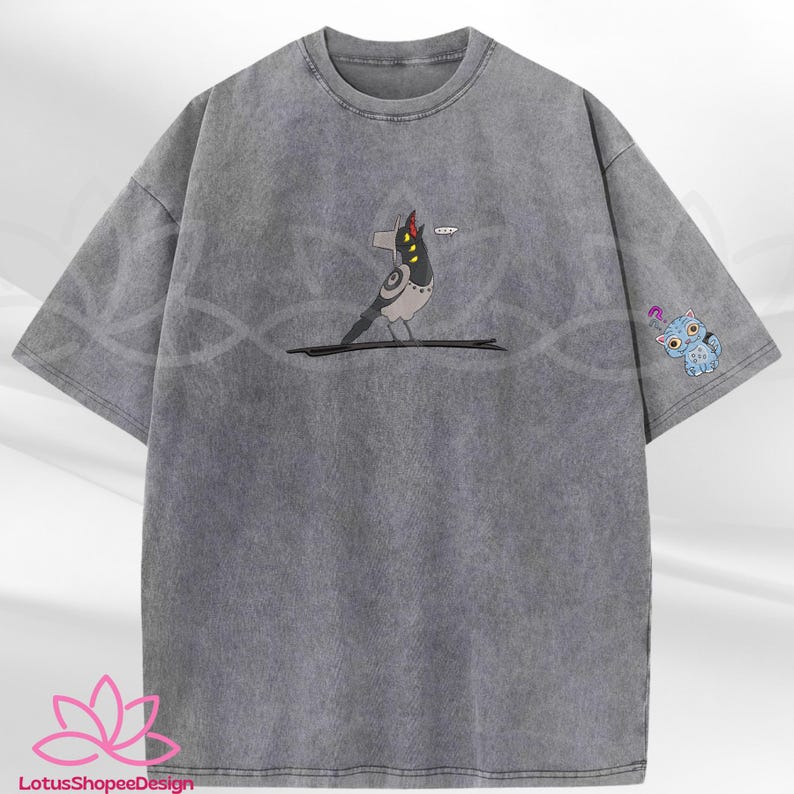 May include: A gray, oversized t-shirt with a distressed wash. The shirt features a cartoon bird graphic on the front and a small blue cat graphic on the sleeve. The bird has a speech bubble.
