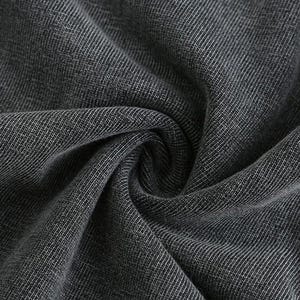May include: Close-up of a dark grey fabric with a textured weave. The fabric is folded and draped, creating shadows and highlights that emphasise the texture and depth of the material. The weave pattern is visible throughout.