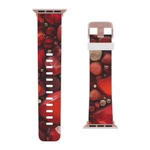May include: A red and gold Apple Watch band with a pattern of red and brown stones. The band is made of silicone and has a rose gold buckle.