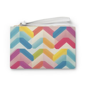 May include: A white clutch purse with a zipper closure and a white wrist strap. The purse features a colorful geometric pattern with shades of blue, pink, yellow, and green.