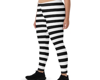 Puede incluir: Leggings a rayas blancas y negras. Los leggings presentan amplias rayas horizontales en blanco y negro. La prenda es entallada y parece estar hecha de un material elástico. Los leggings se llevan con zapatillas deportivas negras.