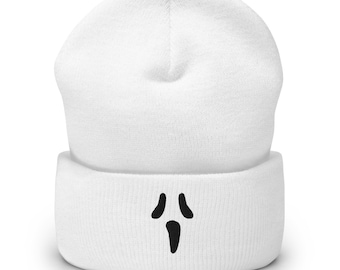 Può includere: Un berretto bianco con un design a forma di volto di fantasma nero. Il berretto è realizzato in un materiale morbido e lavorato a maglia. Il volto del fantasma ha due piccoli occhi ovali e una bocca lunga e verticale.