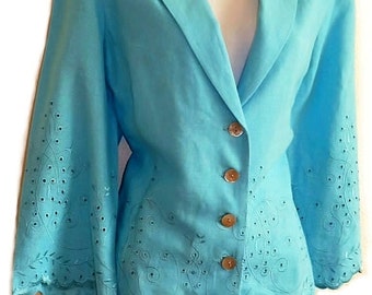 Pode incluir: Um blazer turquesa brilhante com mangas compridas de punhos largos, lapela entalhada e quatro botões frontais. A peça é decorada com intrincados bordados brancos em ilhós com padrões de redemoinho na bainha e nas mangas.