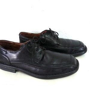 May include: A pair of black leather lace-up shoes with a slightly pointed toe.