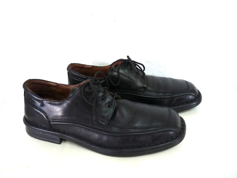 May include: A pair of black leather lace-up shoes with a slightly pointed toe.